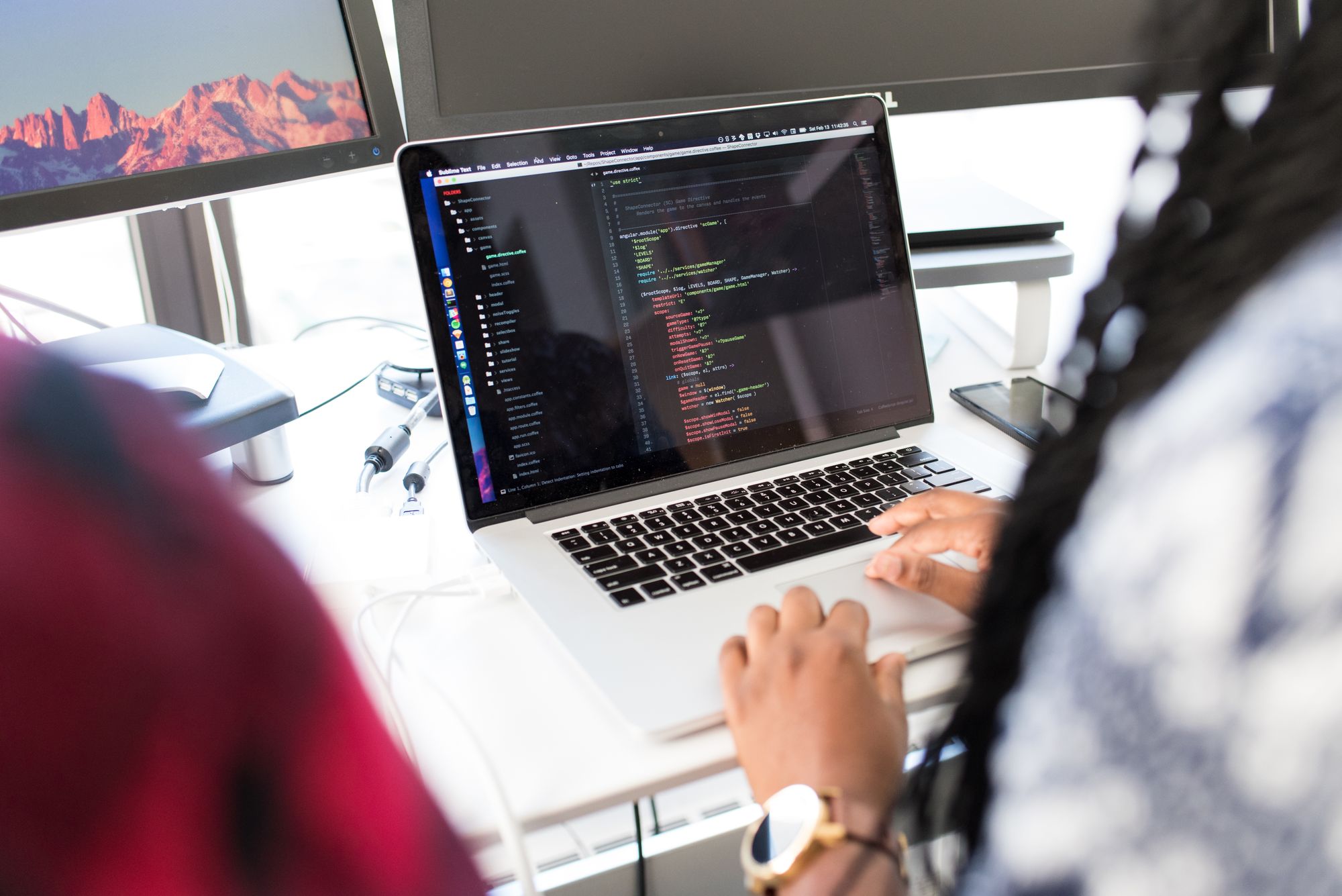 Black woman working on laptop in modern tech office